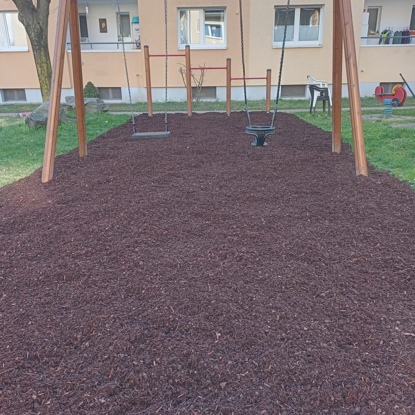 Spielplatz mit Schaukel Spielplatz mit Schaukeln und braunem Mulchboden.